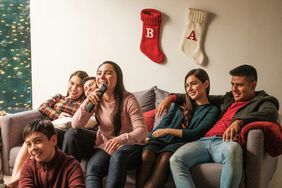 Young latin people sitting on sofa at home during christmas