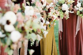 bridesmaids holding burgundy and mustard floral bouquets for wedding