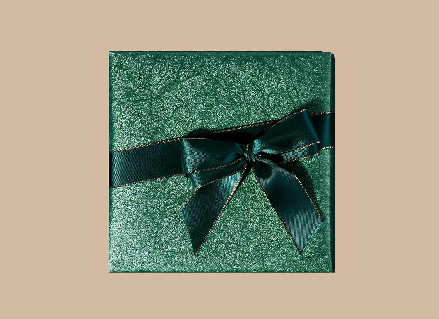 green gift with bow on beige background