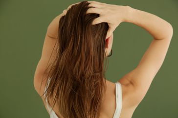 massaging hair oil into scalp with fingers