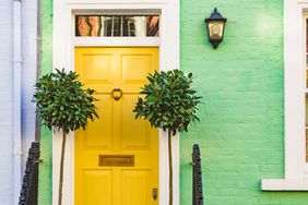 yellow door on green brick house