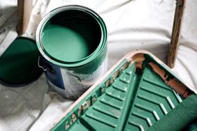 Dark green paint can with paint supplies