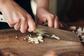 chopping garlic on wood cutting board