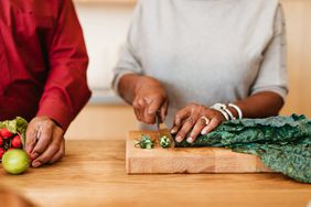 close up of hands chopping vegetables