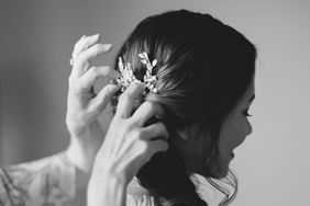 mother putting decorative clip in bride's hair