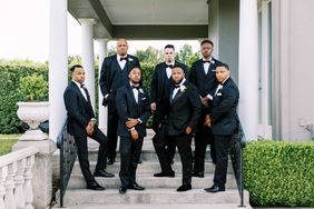 groom with groomsmen in classic black suits outside