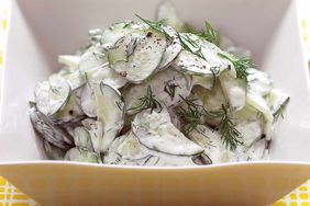 cucumber salad with sour cream and dill dressing in bowl