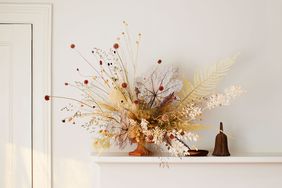 vase of dried flowers displayed on a white mantel
