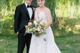 bride and groom smiling standing under willow tree