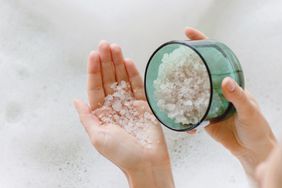 Woman adding epsom salt to bath