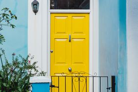 yellow front door on a blue house