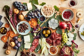 grazing board with cheese meats almonds olives and pomegranate