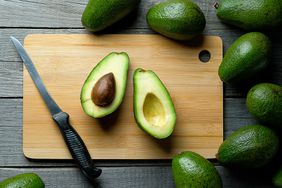 overhead view of a cut avocado on board