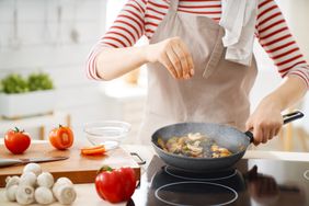 Woman salting food while cooking
