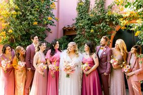 bride with bridesmaids in pink toned dresses and suits