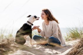 woman and pet dog on the beach