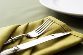 Polished silver cutlery on green napkin