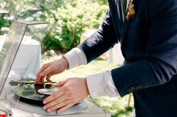 groom placing a record on a turntable