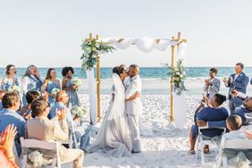 couple kissing at beach wedding ceremony