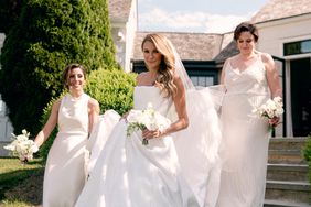 bridesmaids walking with bride carrying her dress