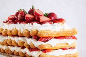 strawberries-and-cream stack cake topped with fresh strawberries