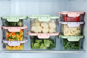 Containers with different frozen vegetables in refrigerator