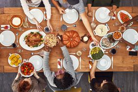 Shot of a group of people sitting together at a dining table ready to eat Thanksgiving meal